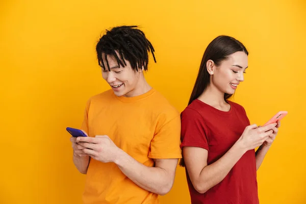 Jovem Casal Multirracial Sorrindo Usando Telefones Celulares Isolados Sobre Parede — Fotografia de Stock