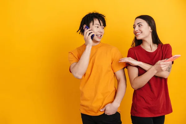 Jovem Casal Multirracial Sorrindo Usar Falar Celulares Isolados Sobre Parede — Fotografia de Stock