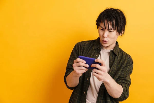 Glad Asiatisk Man Står Över Gul Vägg Bakgrund Med Mobiltelefon — Stockfoto