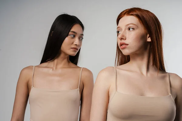 Dos Jóvenes Mujeres Multiétnicas Posando Juntas Sobre Fondo Gris — Foto de Stock