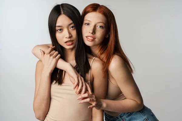 Dos Jóvenes Mujeres Multiétnicas Pie Posando Juntas Sobre Fondo Gris — Foto de Stock