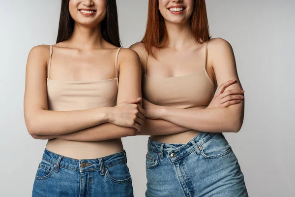 Multiracial Två Kvinnor Ler Samtidigt Poserar Med Armarna Korsade Isolerade — Stockfoto