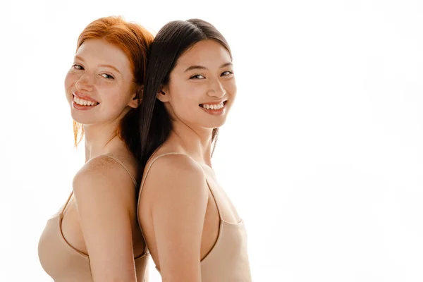 Δύο Πολυφυλετικές Γυναίκες Γελάνε Ενώ Στέκονται Πλάτη Πλάτη Απομονωμένες Πάνω — Φωτογραφία Αρχείου