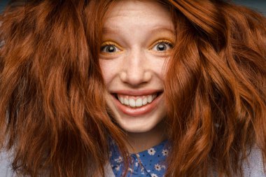 Genç kızıl neşeli kadın gülümseyen ve kameraya bakan.