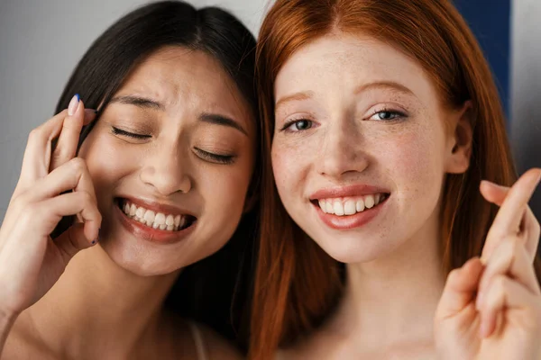 Dos Jóvenes Sonrientes Mujeres Multiétnicas Pie Juntas Sobre Fondo Blanco — Foto de Stock