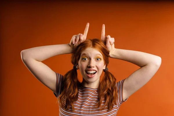 Ung Ingefära Underhållande Kvinna Ler Och Visar Horn Med Fingrar — Stockfoto