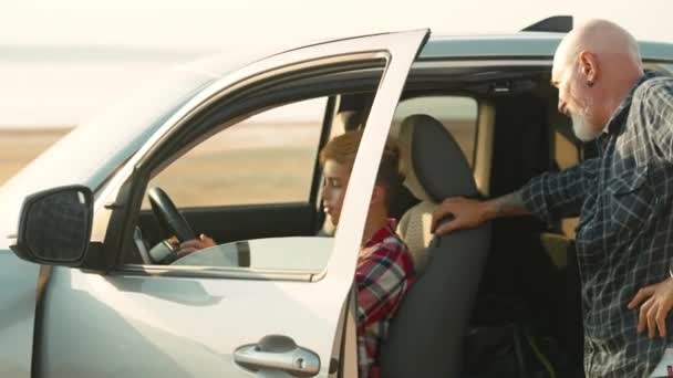 幸せな父は彼の小さな息子が自然にピックアップ車に乗って旅行中に運転席に座ることができます — ストック動画