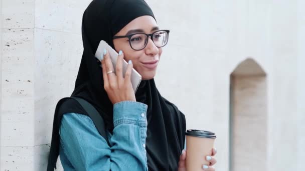 Egy Mosolygó Arab Aki Nemzeti Hidzsábot Visel Beszél Telefonján Miközben — Stock videók