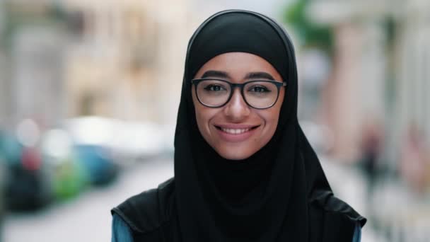 一个身穿黑色国徽的快乐的阿拉伯女人站在街上对着摄像机笑着 这是一张特写 — 图库视频影像