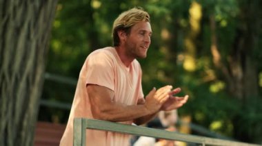 Mutlu bir adam yazın tribünlerde ayakta alkışlıyor.