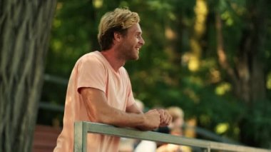 Mutlu bir baba hayranı yazın parkta ayakta duruyor.