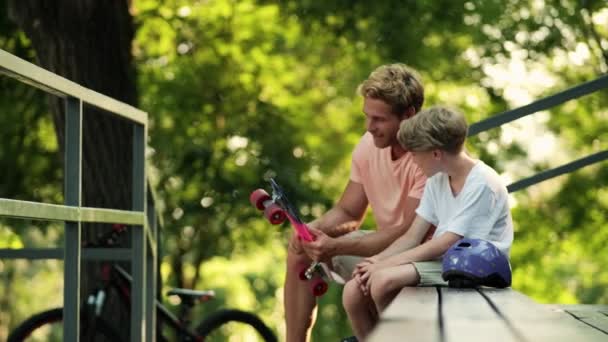 Ein Lächelnder Vater Unterhält Sich Mit Seinem Kleinen Jungen Während — Stockvideo