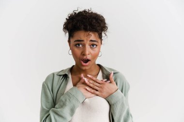 Excited casually dressed young african woman standing over white wall background