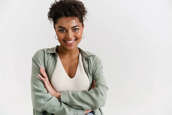 Young black woman in shirt smiling and looking at camera isolated over white background