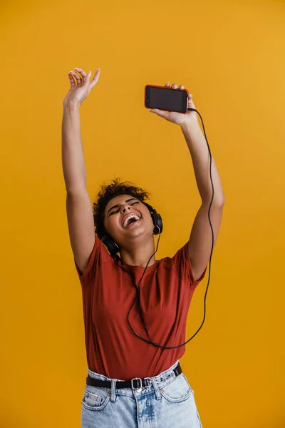 Laughing Black Woman Listening Music Headphones Cellphone Isolated Yellow Background —  Fotos de Stock