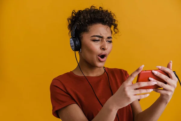 Surprised Black Woman Listening Music Headphones Cellphone Isolated Yellow Background — Foto Stock