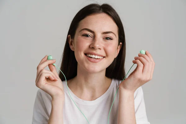 Joven Morena Sonriendo Mientras Posa Con Auriculares Aislados Sobre Fondo —  Fotos de Stock