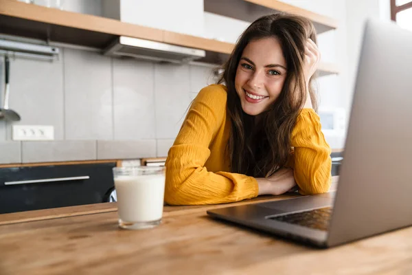 Smiling Brunette Young Woman Sitting Kitchen Table Laptop Computer - Stock-foto