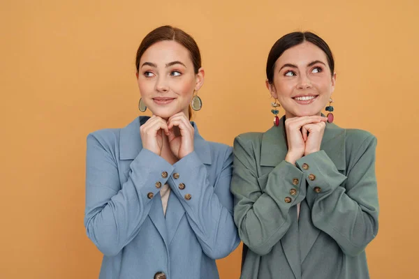 Молоді Дві Жінки Куртках Посміхаються Дивляться Протилежні Сторони Ізольовані Жовтому — стокове фото