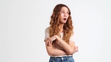 Sıkılmış bir kadın esniyor. Stüdyoda beyaz bir duvarın üzerinde tek başına duruyor.