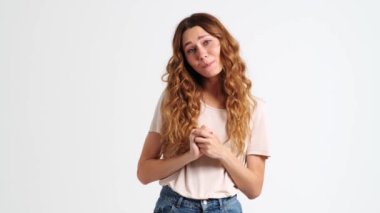 Olumlu bir kadın, stüdyodaki beyaz bir duvarın ardında iç açıcı bir jest yapıyor.