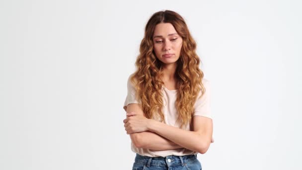 スタジオの白い壁の上に立っている悲しい動揺の女性 — ストック動画