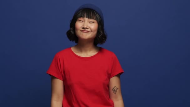 Una Mujer Asiática Sonriente Está Tramando Algo Pie Aislado Sobre — Vídeos de Stock