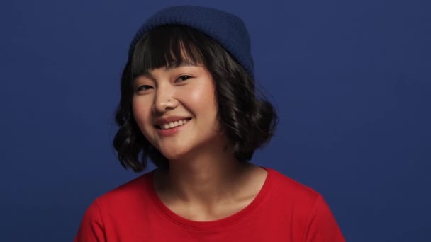 Güzel Bir Asyalı Kadın Kameraya Poz Veriyor Stüdyonun Mavi Duvarında — Stok video