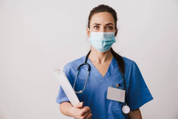 Självsäker Ung Kvinna Läkare Specialist Bär Uniform Innehav Anteckningsblock Isolerad — Stockfoto