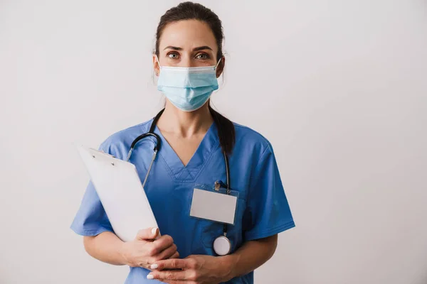 Självsäker Ung Kvinna Läkare Specialist Bär Uniform Innehav Anteckningsblock Isolerad — Stockfoto