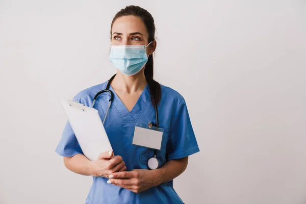Självsäker Ung Kvinna Läkare Specialist Bär Uniform Innehav Anteckningsblock Isolerad — Stockfoto