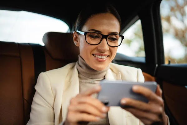 Hermosa Mujer Negocios Sonriente Utilizando Teléfono Móvil Mientras Está Sentado — Foto de Stock