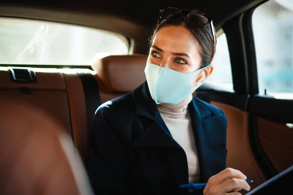 Ciddi Bir Kadınının Yüz Maskesi Takmış Arabada Oturup Defterine Notlar — Stok fotoğraf