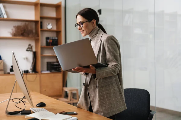 Ofiste Bilgisayarla Laptopla Çalışan Gözlüklü Gülümseyen Çekici Kadın — Stok fotoğraf