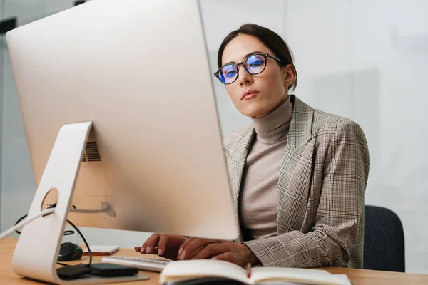 Enfocado Encantadora Mujer Gafas Que Trabajan Con Computadora Mientras Está —  Fotos de Stock