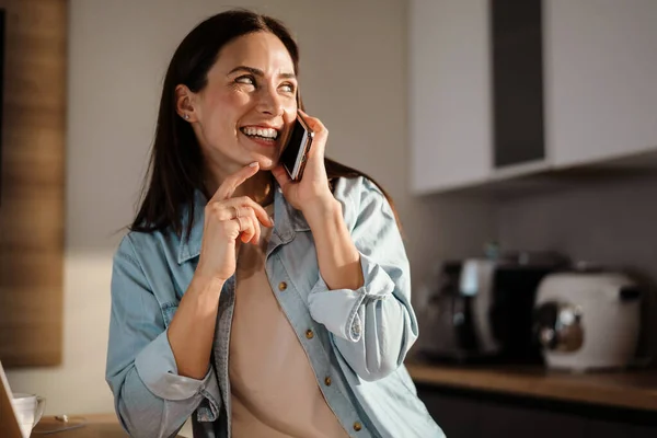 Ευτυχισμένη Γοητευτική Γυναίκα Χαμογελώντας Ενώ Μιλάμε Στο Smartphone Στο Σπίτι — Φωτογραφία Αρχείου