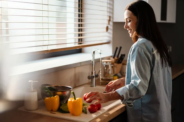 Souriante Jeune Femme Laver Les Légumes Dans Évier Dans Cuisine — Photo