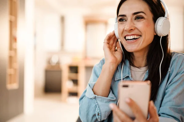 Felice Bella Donna Cuffia Ridere Mentre Utilizza Telefono Cellulare Casa — Foto Stock