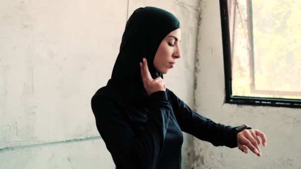 一位漂亮的阿拉伯女运动员带着全国性的头巾 一边用健身追踪器测量自己的脉搏 — 图库视频影像