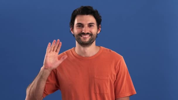Щасливий Брюнетка Людина Махає Рукою Показує Мирний Жест Стоїть Ізольовано — стокове відео