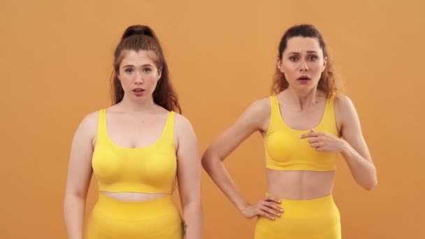 Two Serious Women Friends Wearing Yellow Sport Suits Giving Negative — Stock Video