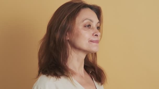 Vacker Medelålders Brunett Kvinna Ler Mot Kameran Isolerad Över Beige — Stockvideo