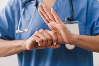 Beyaz arka planda ellerini sterilize eden bir kadın doktora yaklaş.