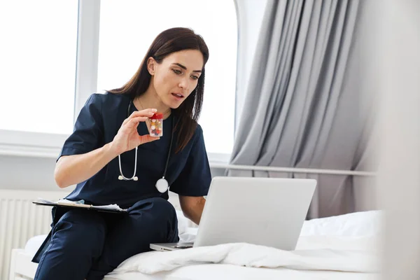 Seorang Dokter Wanita Dalam Seragam Medis Menunjukkan Pil Kamera Laptop — Stok Foto
