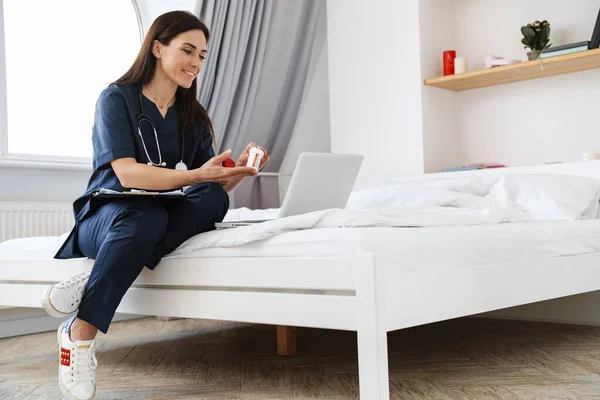 Tıbbi Kıyafetli Kadın Doktor Laptopla Video Görüşmesiyle Konuşuyor Odadaki Yatakta — Stok fotoğraf
