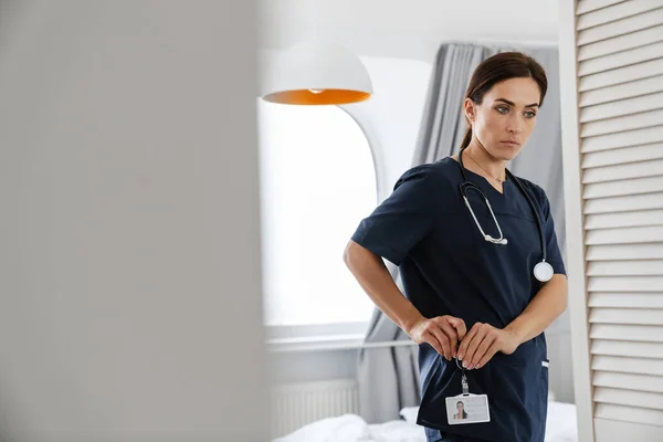 Médico Mujer Media Enfocado Insignia Sujeción Traje Médico Mientras Está — Foto de Stock