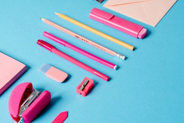 Mektup, kalem, kalem, silgi, zımba, mavi bir stüdyoda duran kağıt içeren bir setin yakın plan görüntüsü