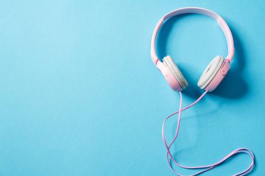 Mavi stüdyoda, kameranın sağında duran pembe bir kulaklığın yukarıdan görünüşü.