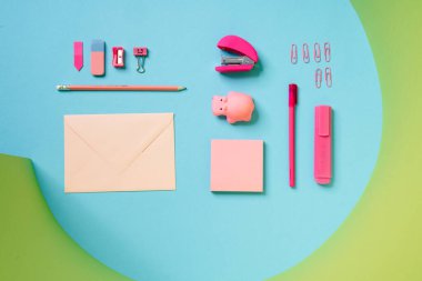 Bir zarf, bir kalem, bir bileyici, ataç ve stüdyoda duran bir keçeli kalemden oluşan pembe çocuk seti.