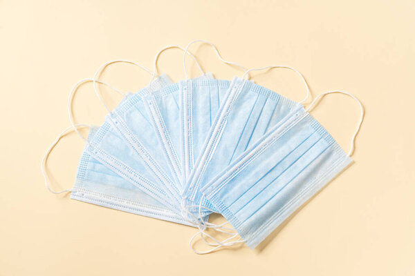 The fan of a disposable protective masks lying in a beige studio